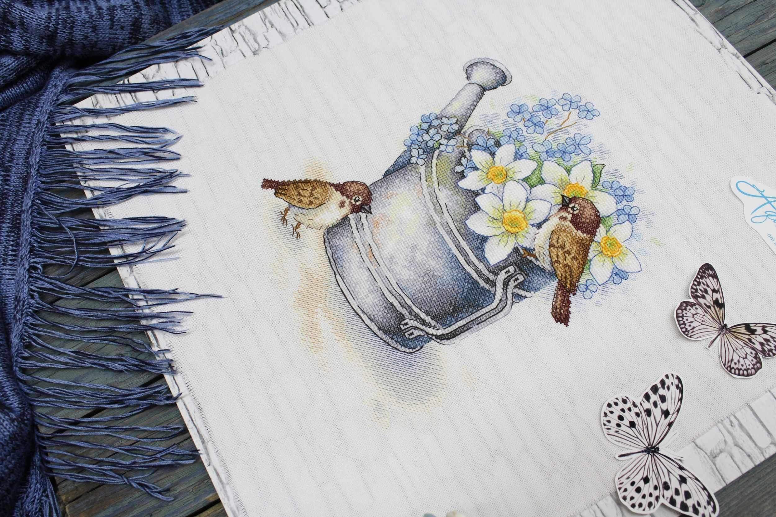 Daffodil Lovers SA-026 Cross-stitch kit featuring a watering can, white chamomiles, blue flowers, and a bullfinch on 27 count canvas.